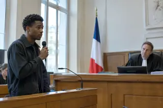 Un jeune rappeur face à un juge dans une salle d’audience française, lumière naturelle, atmosphère sérieuse et calme.